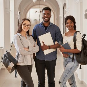Africans and Caucasian standing on corridor of university. Programa de Beneficios